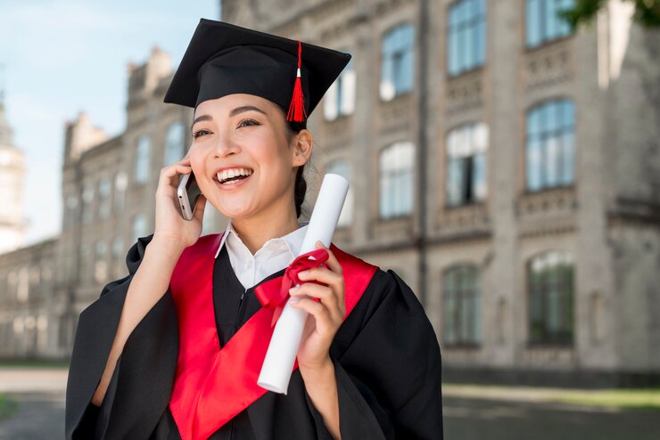 A MBA grad holding degree in hand and talking on phone on convocation